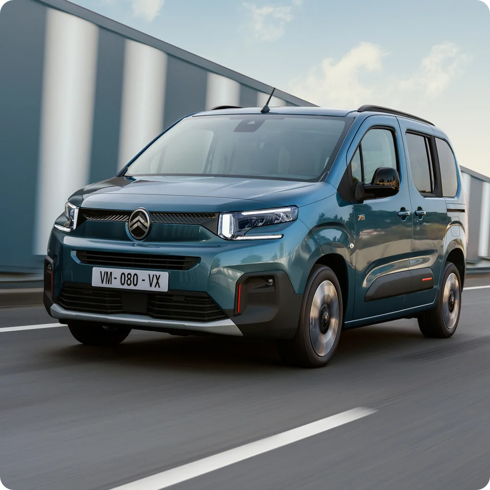 Widok z przodu Kiama Blue ë-Berlingo jadącego pokazujący zasięg elektryczny, efektywność, bezpieczeństwo oraz pewną swobodę podróży na długich dystansach