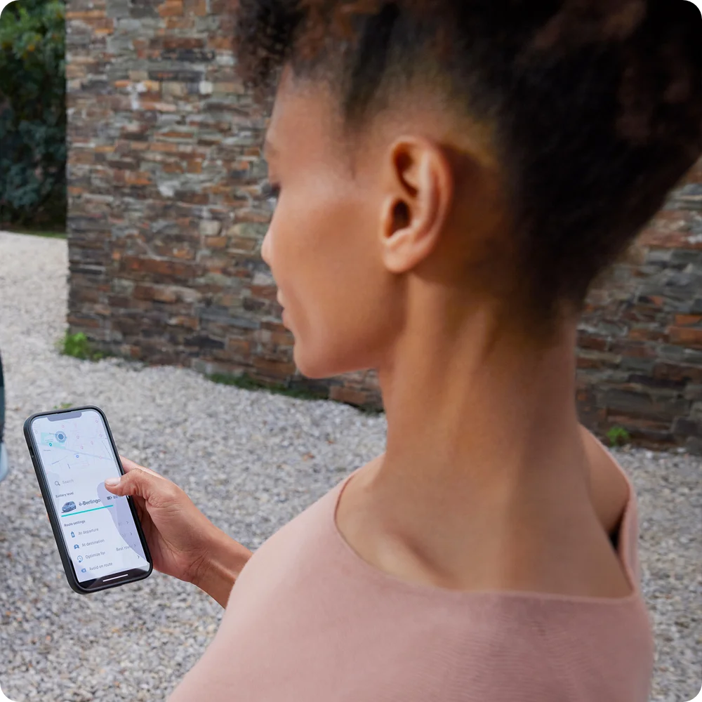 Osoba korzystająca za aplikacji Free2Move Charge na smartfonie jako ilustracja funkcji do sprawnego planowania trasy i wyszukiwania lokalizacji stacji ładowania dostępnych dla użytkowników Citroëna ë-C3 Van.