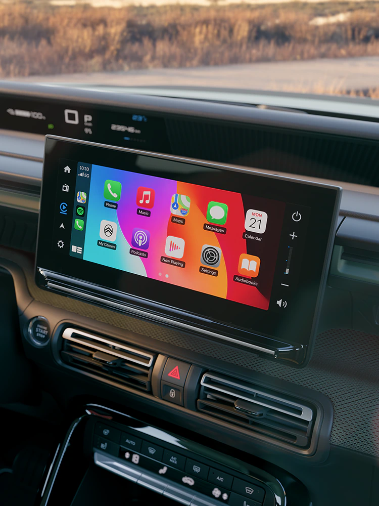 Zbliżenie na ekran dotykowy na desce rozdzielczej Citroëna ë-C3 Outdoor, ukazujące funkcje łączności i komfort Advanced Comfort podczas podróży kompaktowym SUV-em