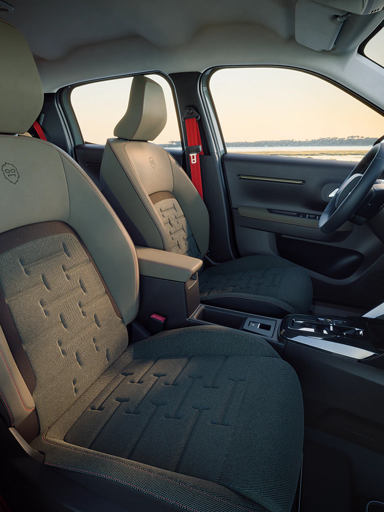 Widok przedniej części wnętrza Citroëna ë-C3 Outdoor, ukazujący fotele Advanced Comfort i przestronną kabinę kompaktowego SUV-a podczas rodzinnych podróży