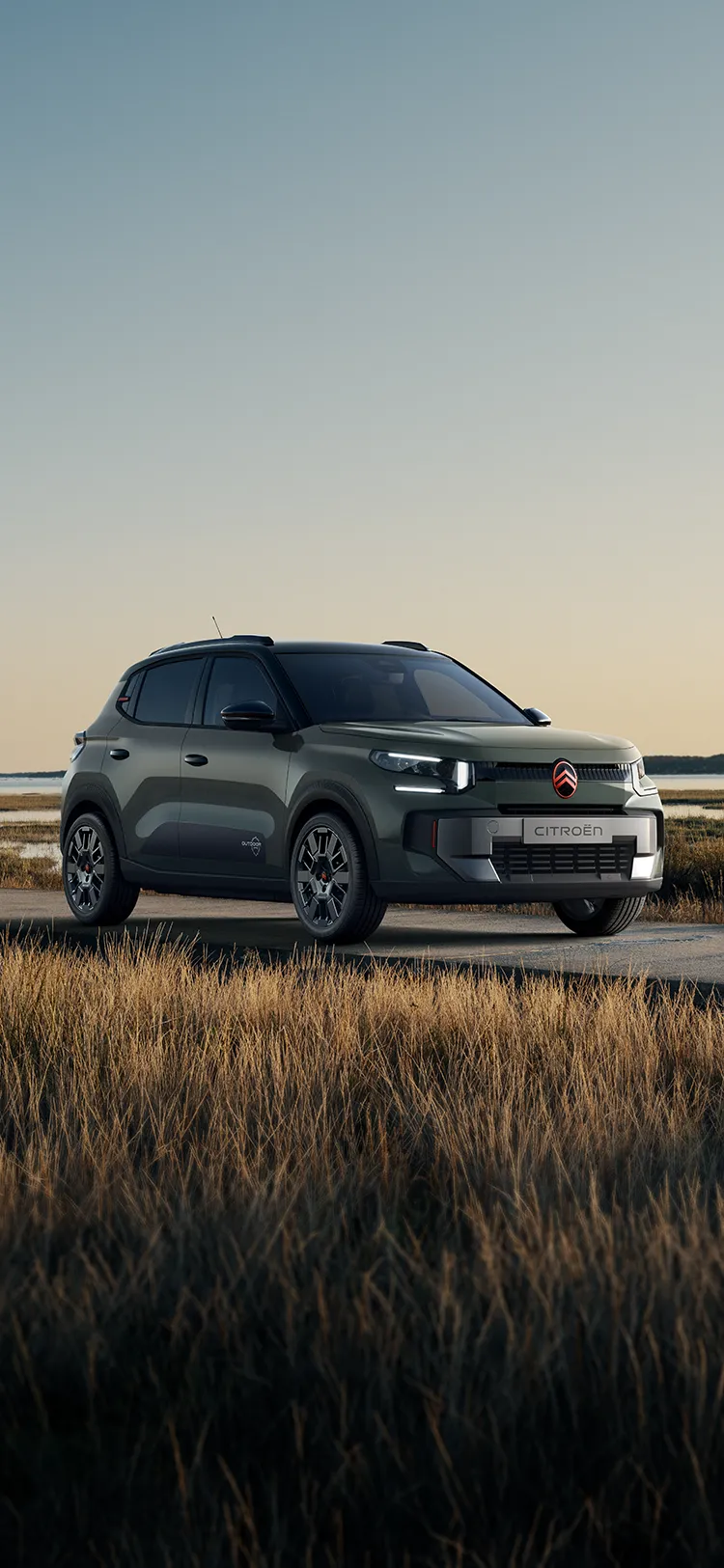 Widok Citroëna C3 Outdoor z przodu pod kątem 3/4, z charakterystycznymi światłami LED, ukazujący komfort Advanced Comfort w otoczeniu nadmorskich mokradeł