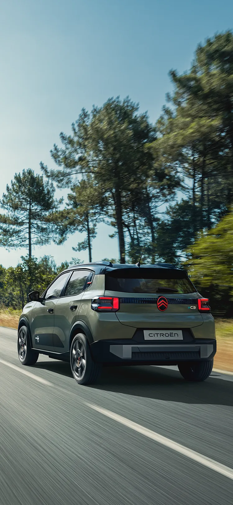 Widok Citroëna C3 Outdoor z tyłu pod kątem 3/4, z tylnymi światłami LED, ukazujący komfort Advanced Comfort podczas jazdy otwartą drogą
