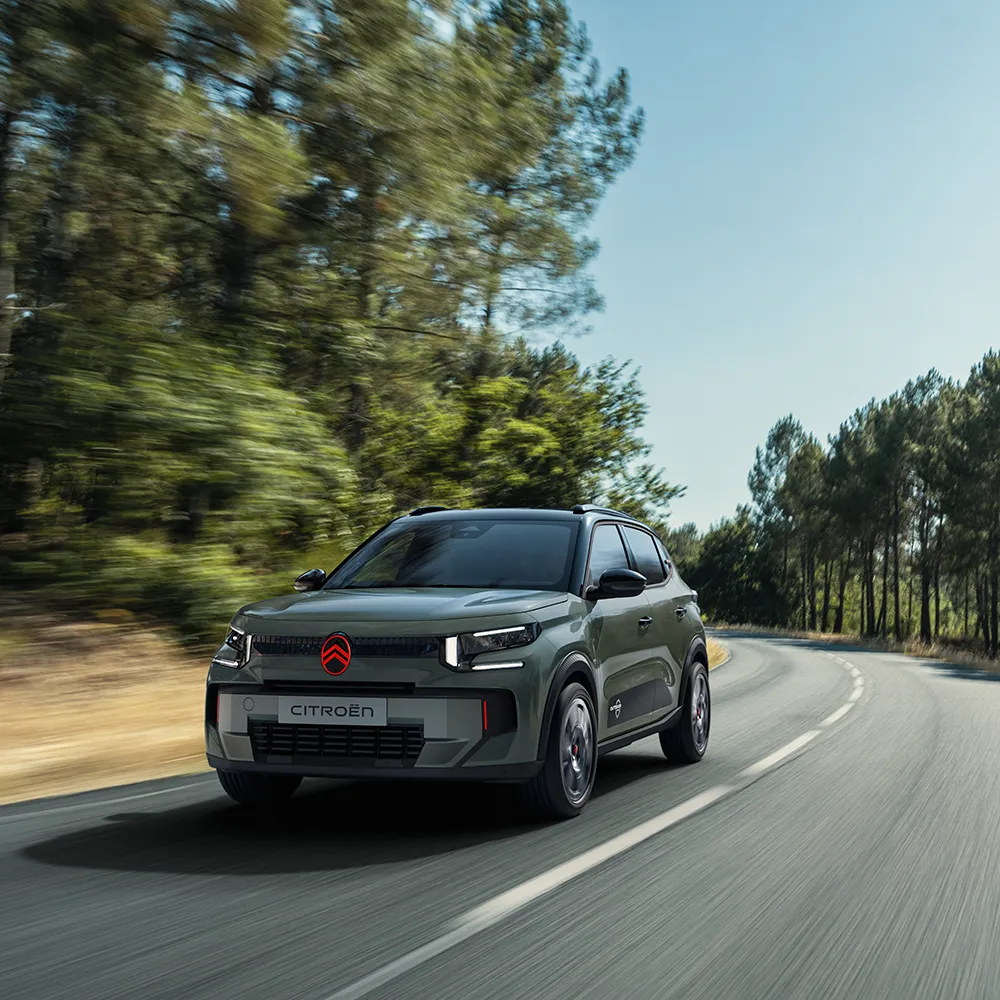 Widok Citroëna C3 Outdoor z przodu pod kątem 3/4, z charakterystycznymi światłami LED, ukazujący komfort Citroën Advanced Comfort podczas podróży malowniczą trasą