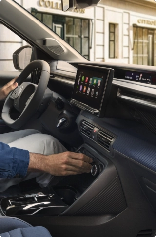 Widok wnętrza kompaktowego SUV-a Citroën C3, podkreślający zaawansowany system multimedialny i elementy sterowania na kierownicy, zapewniające komfort na co dzień oraz stanowiące inteligentną alternatywę dla samochodów elektrycznych.