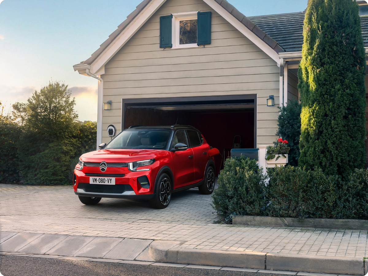 Ujęcie z przodu 3/4 elektrycznego SUV-a Citroëna ë-C3 w plenerze, prezentujące nowoczesny design dla pewnej, efektywnej i przystępnej mobilności miejskiej.