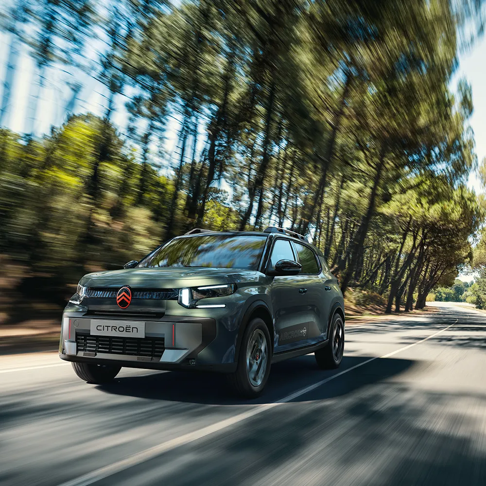Widok Citroëna C3 Aircross Outdoor z przodu pod kątem 3/4, ukazujący przestronność, wszechstronność i komfort SUV-a o innowacyjnej stylistyce podczas rodzinnych podróży