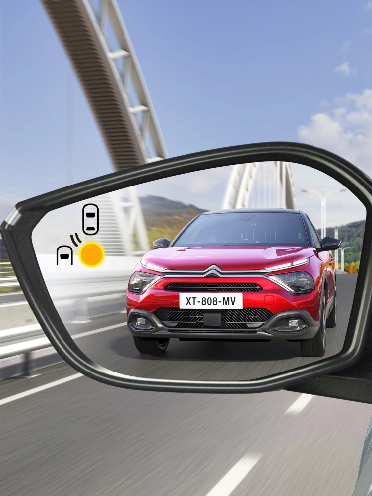 Alert systemu monitorowania martwego pola w lusterku Citroëna C4 X pokazujący pojazd zbliżający się z tyłu.