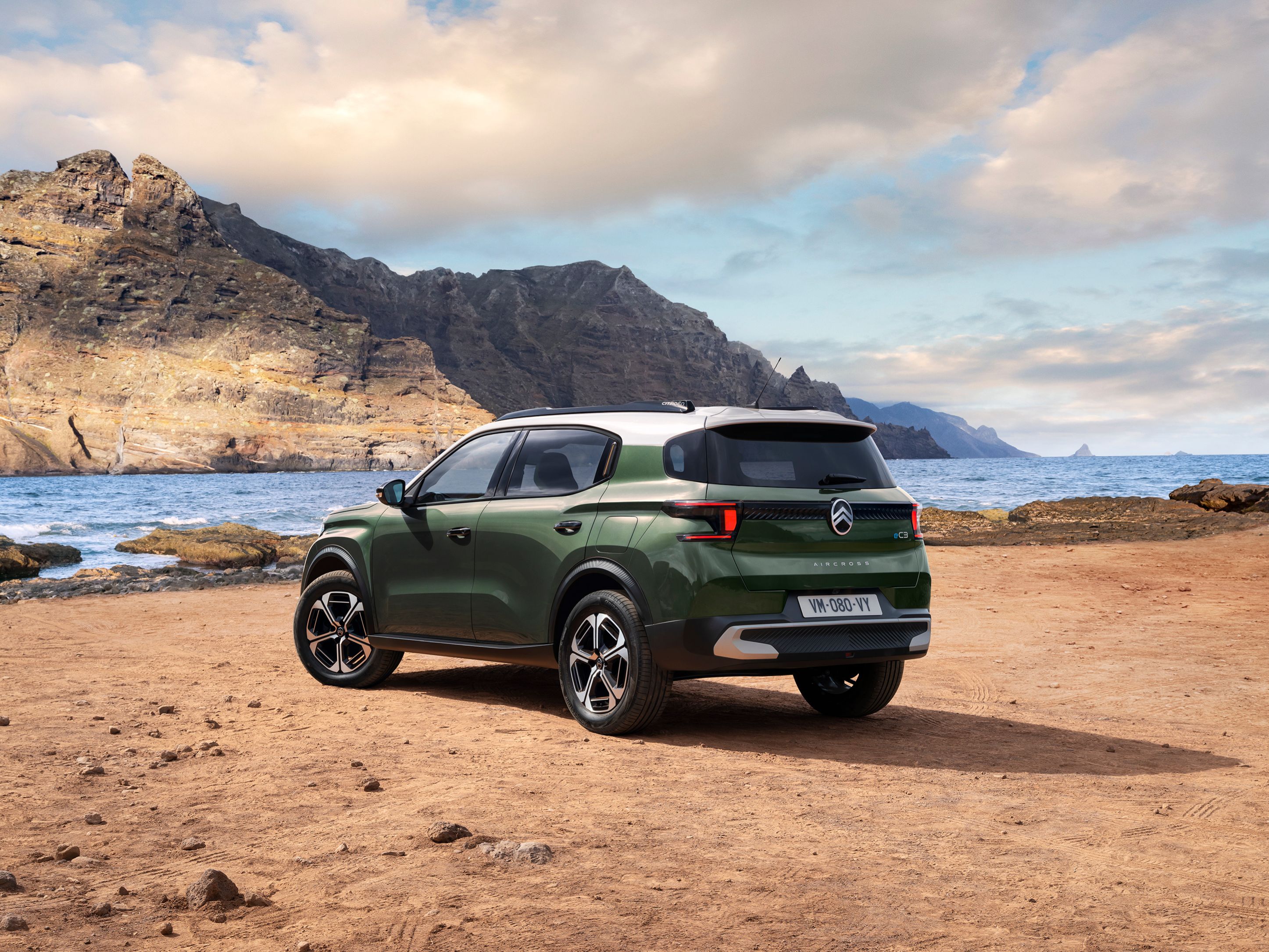 Widok z tyłu pod kątem 3/4 Citroëna C3 Aircross SUV nad morzem, prezentujący nowoczesny design SUV-a dla wszechstronnej i przystępnej mobilności.