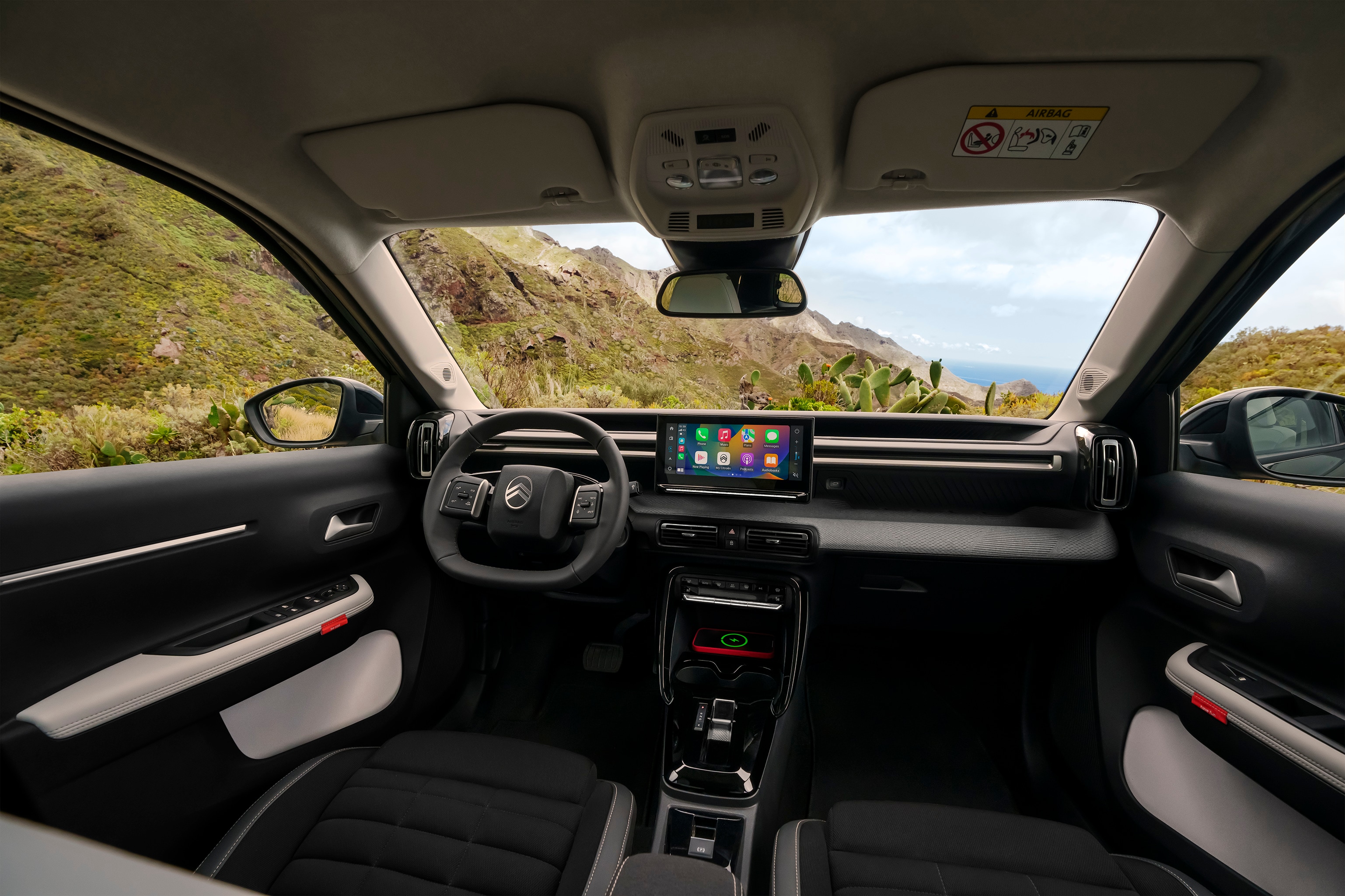 Widok wnętrza z przodu SUV-a Citroëna C3 Aircross prezentujący panoramiczną deskę rozdzielczą i duży ekran dotykowy dla intuicyjnej, przestronnej i przystępnej jazdy na co dzień.