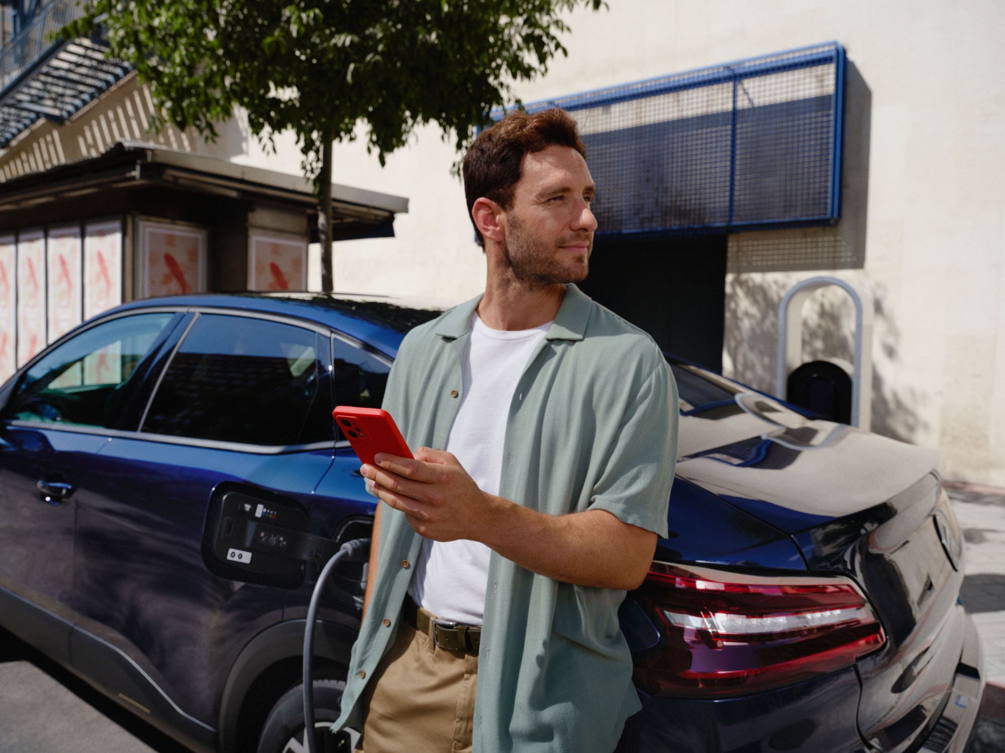 Scena ładowania Citroëna C4 X z wykorzystaniem łączności pokazująca użycie aplikacji dla wygodnej elektrycznej mobilności na co dzień.