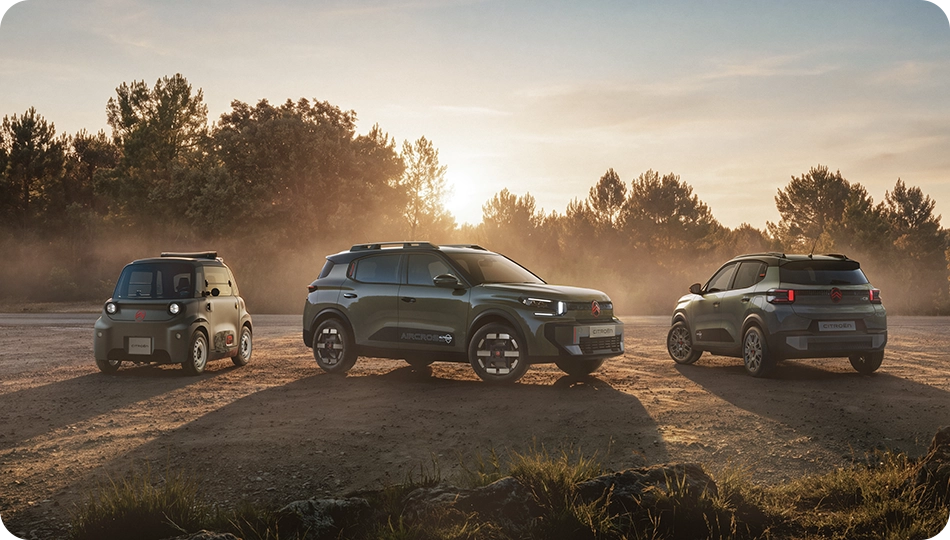 Widok gamy Citroëna z ujęcia 3/4, ukazujący przestronne, wszechstronne i komfortowe modele o innowacyjnym outdoorowym charakterze: ë-C3 Outdoor, ë-C3 Aircross Outdoor i Ami Outdoor, prezentujące trzy uzupełniające się modele w outdoorowym otoczeniu